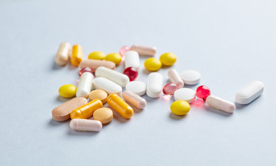 Vitamins and supplements on bright paper background. Concept for a healthy dietary supplementation. Close up. Copy space. 