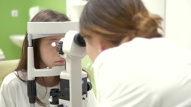 The concept of ophthalmology, optometry. Medical ophthalmic device for eye examination. teenage girl checks eyesight at a doctor appointment, on equipment.