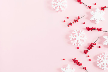 Christmas modern composition. Xmas decorations, red berries, snowflakes on pastel pink background. Christmas, New Year, winter concept. Flat lay, top view, copy space