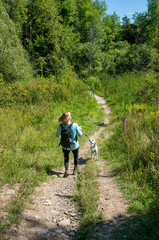 Obraz premium Woman walking her dog on a hiking trail