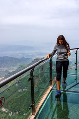 Caucasian white woman walking on glass walkway, Sky Walk at Tianmen Mountain