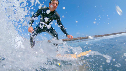 Fototapeta na wymiar LOW ANGLE, UNDERWATER: Young surfer riding a fast barrel wave in sunny Lobos.