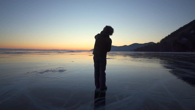 Full length of tourist photographing beautiful sunset at Lake Baikal
