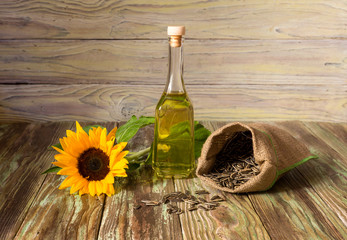 Sunflower seeds and sunflower oil on a wooden background