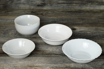 Empty ceramic white bowls on wooden background