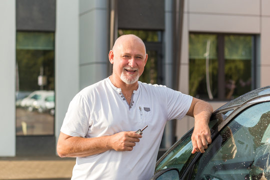 Middle Aged Man Renting A Car, Holding Keys. Transportation, Transport Concept