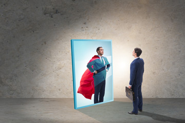 Businessman seeing himself in mirror as superhero