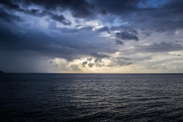 Sunset rays shining through the clouds over the ocean