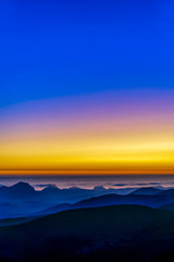 Yellow, blue sunset, Ocean, Mountains, silhouetted