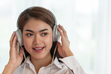 Young Asian woman enjoy listening to music with headphones, happy and relaxing time