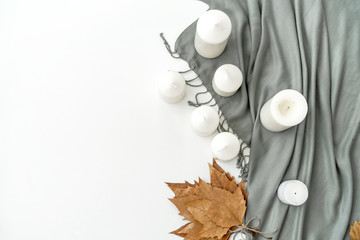 Home office desk workspace with scarf, candles, maple  leafs on white background. Flat lay, top view modern minimalist blog header template