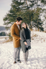 Fototapeta premium happy young couple walking through the park on a snowy day