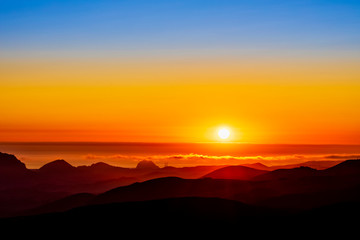 Orange Sunset, Hills, Ocean, silhouetted