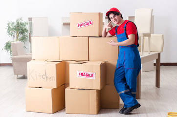 Young male contractor with boxes working indoors