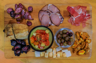 Board of traditional Portuguese food with blood and pork sausage, ham, bread, olives at a restaurant in Porto, Portugual