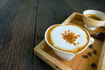 Coffee cups and coffee beanson wood background.