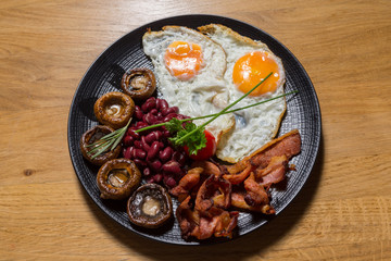 Bacon and eggs served with beans and mushrooms