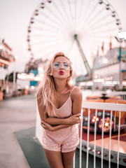 Portrait of young woman blowing kiss in amusement park