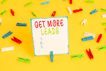 Handwriting text Get More Leads. Conceptual photo to have more customers and improve your target sales Colored clothespin papers empty reminder yellow floor background office