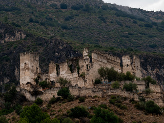 Fototapeta na wymiar castillo abandonado y derruido sobre la colina de una montaña