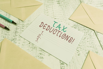 Word writing text Tax Deductions. Business photo showcasing reduction income that is able to be taxed of expenses Envelopes highlighters ruled paper sheet wooden retro vintage background