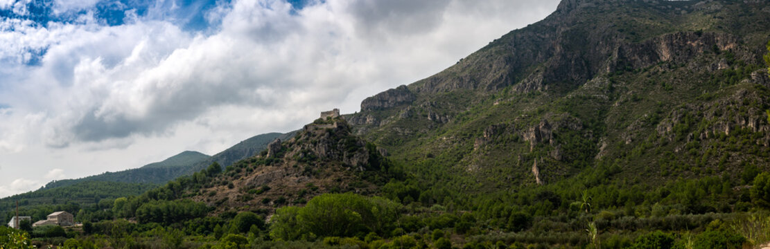 fotografia panorámica de castillo sobre la colina de una montaña y nave industrial en ruinas