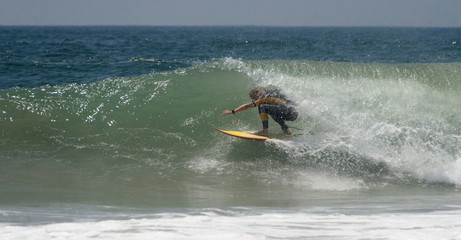 A Surfer rides a big Wave At Newport Beach In California
