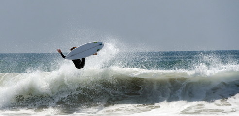 A Surfer jumps a big Wave At Newport Beach In California