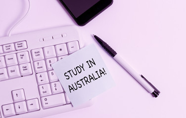 Handwriting text writing Study In Australia. Conceptual photo going into foreign country order complete your studies White pc keyboard with empty note paper above white background