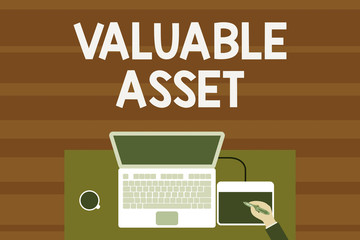 Text sign showing Valuable Asset. Business photo text Your most valuable asset is your ability or capacity Upper view laptop wooden desk worker drawing tablet coffee cup office