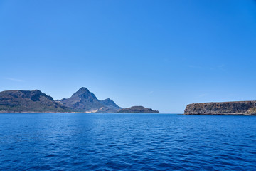  Rocky islands near Crete, Greece, with clear sky on a background and blue sea on a foreground. Copy space.