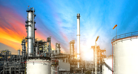 Close-up view Oil and gas industrial refinery zone,Detail of equipment oil pipeline steel with valve from large oil storage tank at cloudy sky. -image