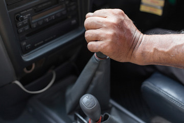 Man hand holding a gear while  driving