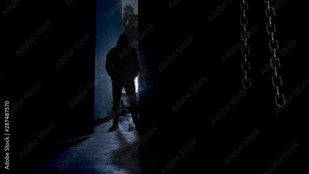 Canvas Prints hooded man behind opening door 4k loop features a dark room with hanging chains swinging and a door 