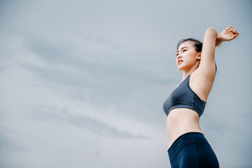 An beautiful Asian woman running and drinking some water during moring. Workout and sport outdoor concept.