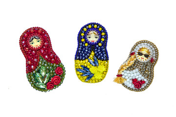 Set of three modern fashion handmade brooches matryoshka in traditional russian style with colorful red and green beads and crystals isolated on white background, folklore and handmade concept, free s