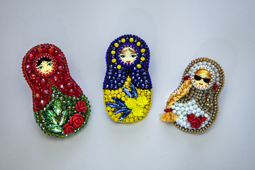 Set of three modern fashion handmade brooches matryoshka in traditional russian style with colorful red and green beads and crystals isolated on white background, folklore and handmade concept, free s