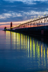 Grand Haven Lighthouse at sunset with catwalk lights reflected in Lake Michigan