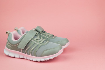 Fitness sneakers on pastel pink background. Color trend.
