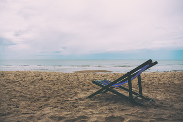 Fototapeta na wymiar A single beach chair by the sea with sky background