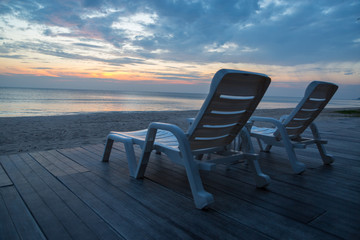 Fototapeta premium White chairs on the beach before sunset background
