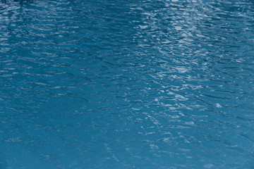Blue swimming pool edge with refection of water ripple