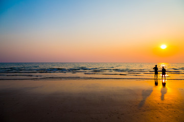 Fototapeta premium Siluate lovers and beach before sunset