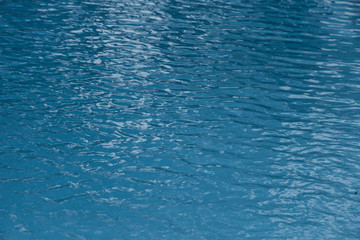 Blue swimming pool edge with refection of water ripple