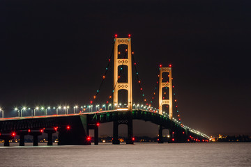 Fototapeta na wymiar The Mackinac Bridge fully illuminated at night. The bridge connects the lower and upper peninsulas of Michigan where Lake Michigan and Lake Huron meet. 