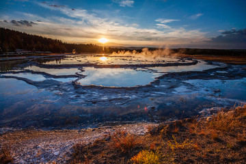 Sunset reflected in the pools of Great Fountain Geyser, Yellowstone National Park, WY 