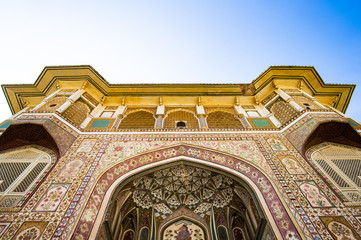 Obraz premium Stunning view of the decorated facade of the Amer Fort in Jaipur during a beautiful sunset. Amer Fort is a fort located in Amer, Rajasthan, India.