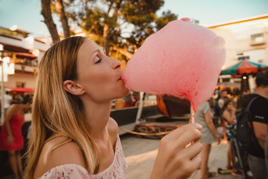  Young woman standing with pink cotton candy