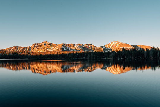 Snowy mountains reflecting in Mirror Lake, in the Uinta Mountains, Utah