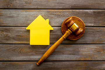 Inscribed gavel, house figure for inheritance concept on wooden background top view